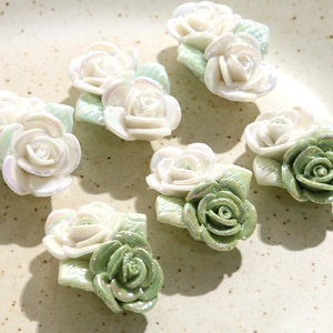 Gros plan de breloques de rose 3D en résine pour bijoux DIY, blanc perle et vert iridescent