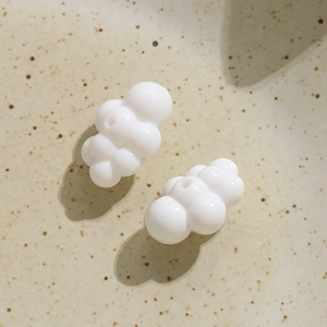 Close-up of glossy white 3D cloud acrylic charms with holes for DIY jewelry making
