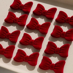 Detail of 12 burgundy velvet bow tie accessories for DIY hair clips in a soft texture