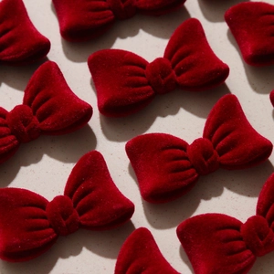 Detailed view of red velvet bow accessories with premium texture for DIY hair clips