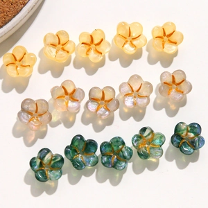 Close-up of glittery acrylic flower charms with golden details for DIY jewelry making