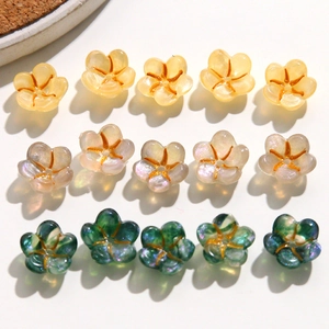 Macro detail of sparkly resin flower charms for DIY nail art and jewelry making