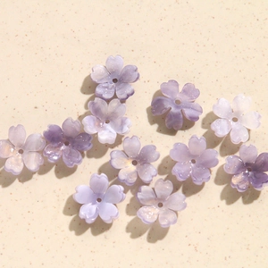 Close-up of pearlized light purple five-petal acrylic flower beads for DIY jewelry making