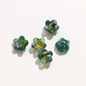 Macro detail of five green floral acrylic beads with glitter for DIY jewelry making