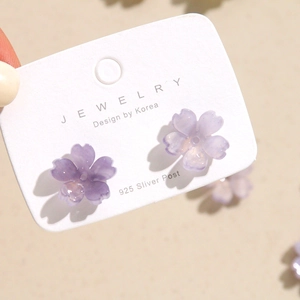 Macro shot of purple cherry blossom acrylic stud earrings with 925 silver post