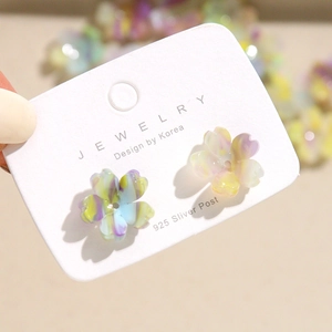 Macro detail of acrylic five-petal flower earrings with marble texture on 925 silver posts