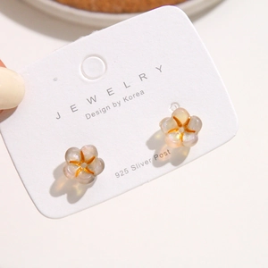 Detail of glitter acrylic flower earrings with 925 silver posts on a display card