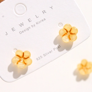 Detailed close-up of amber glitter acrylic flower earring with 925 silver stud on card