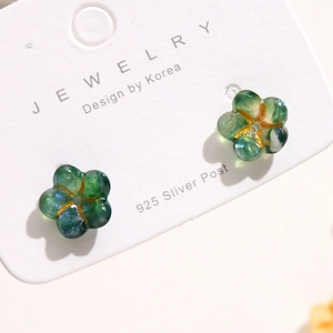 Translucent emerald green floral stud earrings with S925 silver posts on a jewelry card