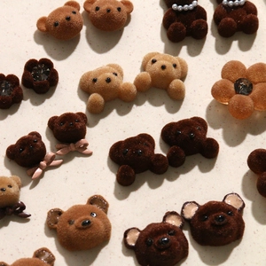 Details van pluchen beer- en bloembedeltjes met strikjes en parels voor DIY-knutselwerk