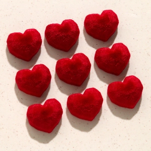 Detailed view of red velvet flocked heart patches for DIY earring and jewelry making