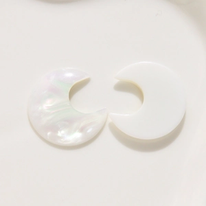 Macro detail of resin crescent moon earring charms with pearlescent and solid finish