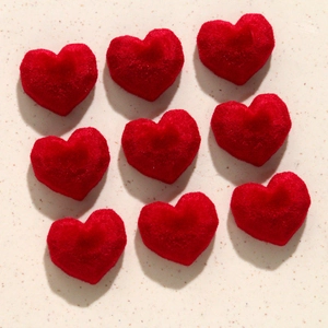 Macro shot of nine red velvet heart pendants with faceted flocking for jewelry making