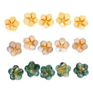 Flat lay of floral acrylic charms in yellow, pearl white, and dark green for DIY jewelry