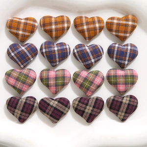 Macro detail of heart-shaped fabric buttons with various colorful plaid patterns