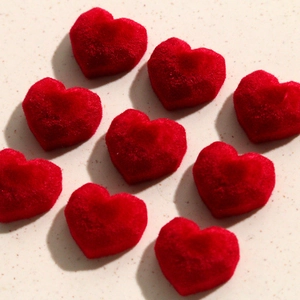 Macro view of red velvet heart-shaped flocked charms for DIY earring making