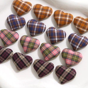 Close-up of heart-shaped plaid fabric charms in yellow, navy, pink, and burgundy