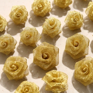 Macro detail of handmade metallic gold mesh rose flower heads for jewelry and hair DIY craft