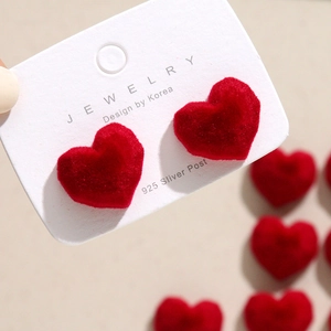 Close-up of red velvet heart earrings on a 925 silver post jewelry display card
