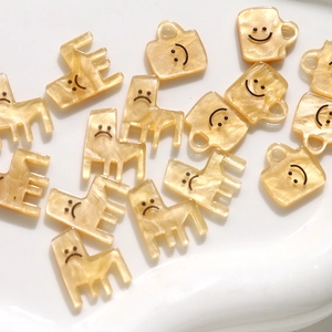 Macro-opname van parelmoer crème bedeltjes in de vorm van een beker voor DIY-sieraden