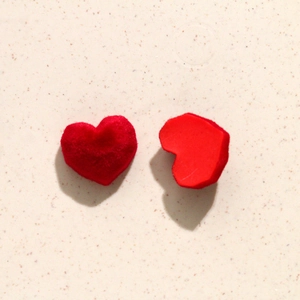 Macro view of red velvet heart charms showing plush texture and flat back for DIY jewelry