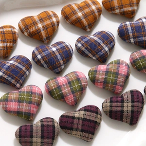 Macro shot of colorful plaid fabric heart patches with soft cotton stuffing and texture