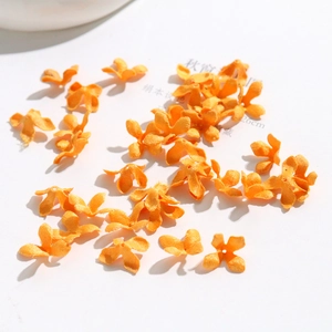 Detailed view of handmade orange fabric osmanthus flower petals for DIY jewelry making