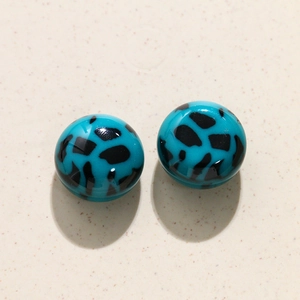 Gedetailleerd zicht op 20 mm turquoise hars cabochons met zwarte luipaardpatronen