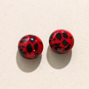 Detail van rood-zwarte harskralen met luipaardprint voor DIY-oorbellen en telefoonhoesjes