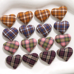 Close-up of 3D plaid fabric heart charms for clothing and DIY craft accessories