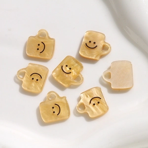 Macro-detail van crème acryl bekerhangers met parelmoeren textuur en smiley-afdrukken