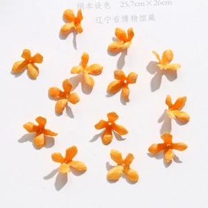 Detailed view of handmade orange silk fabric four-petal flower charms for DIY jewelry