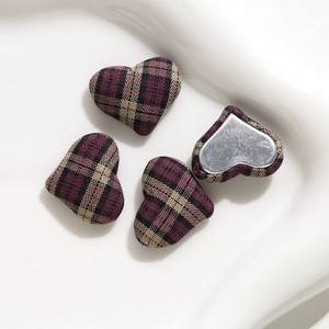 Detail of red and black plaid heart-shaped fabric buttons with flat metal backings