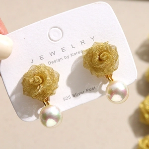 Detail of gold mesh rose earrings with lustrous pearl pendants on 925 silver posts