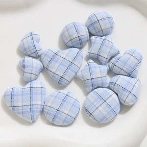 Close-up of blue plaid fabric covered buttons in heart, circle and star shapes