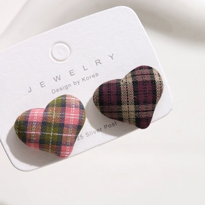 Close-up of heart-shaped plaid fabric earrings with 925 silver posts in two colors