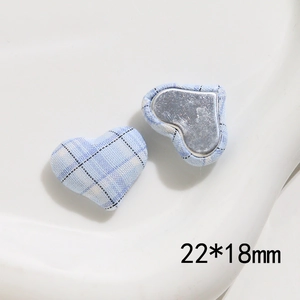 Detail of 22x18mm heart-shaped light blue plaid fabric button with flat metal back