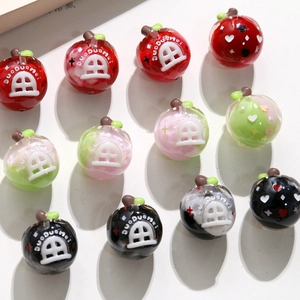 Vue détaillée de perles DIY en forme de pomme colorée avec motifs de maison en 3D
