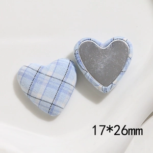 Detailed view of 17x26mm heart-shaped blue gingham fabric button with flat metal back