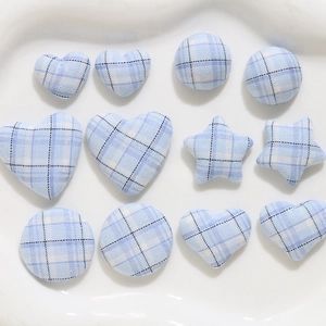 Detailed view of blue plaid fabric covered buttons in star, heart and round shapes