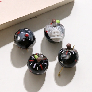Vue détaillée de 4 perles en verre en forme de pomme avec motifs pour bijoux artisanaux