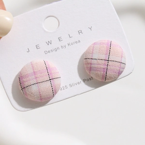 Detail of pink plaid fabric covered round buttons with 925 silver posts for DIY crafts