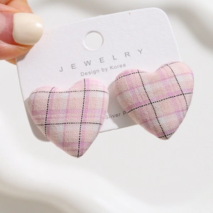 Close-up of pink checkered heart fabric buttons on white jewelry cardstock packaging