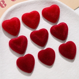 Detailed view of nine red flocked heart-shaped charms for DIY jewelry and crafts
