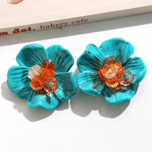 Détail de la fleur en résine turquoise avec texture marbrée et centre en perles brodées