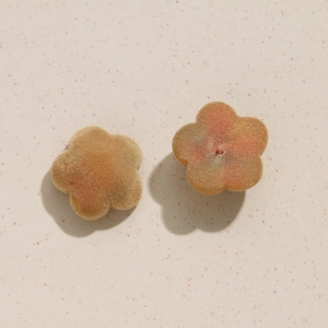 Détail de breloques fleurs en velours pêche pour la création de bijoux DIY et boucles