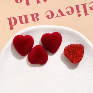 Detail of red velvet and glitter heart-shaped resin charms for DIY craft jewelry making