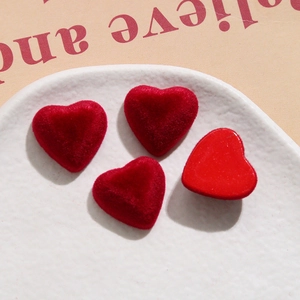 Detailed view of red velvet and glossy heart-shaped resin charms for DIY jewelry and crafts