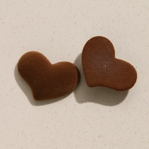 Détail d'accessoires bijoux DIY en forme de cœur floqué marron café avec texture velours