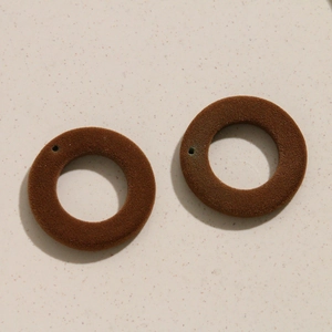 Gros plan détaillé de breloques ovales marron floquées pour la création de boucles d'oreilles DIY